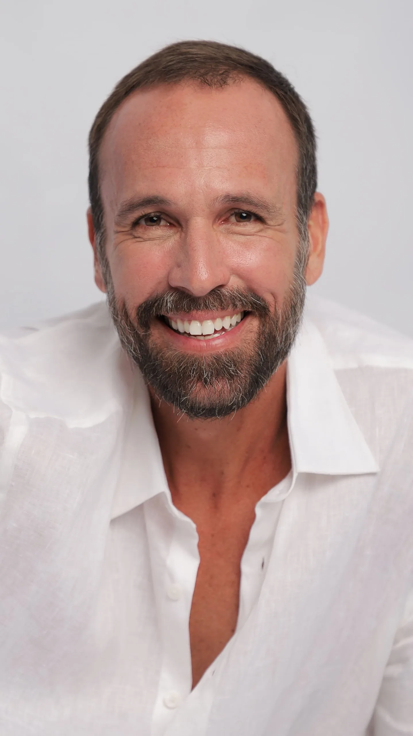 Retrato de Vini Cavalieri sorrindo, de camisa branca