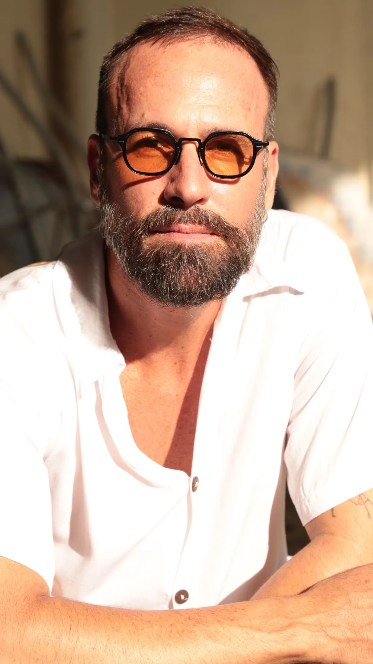 Retrato de Vini Cavalieri de óculos de lentes alaranjadas e camisa branca