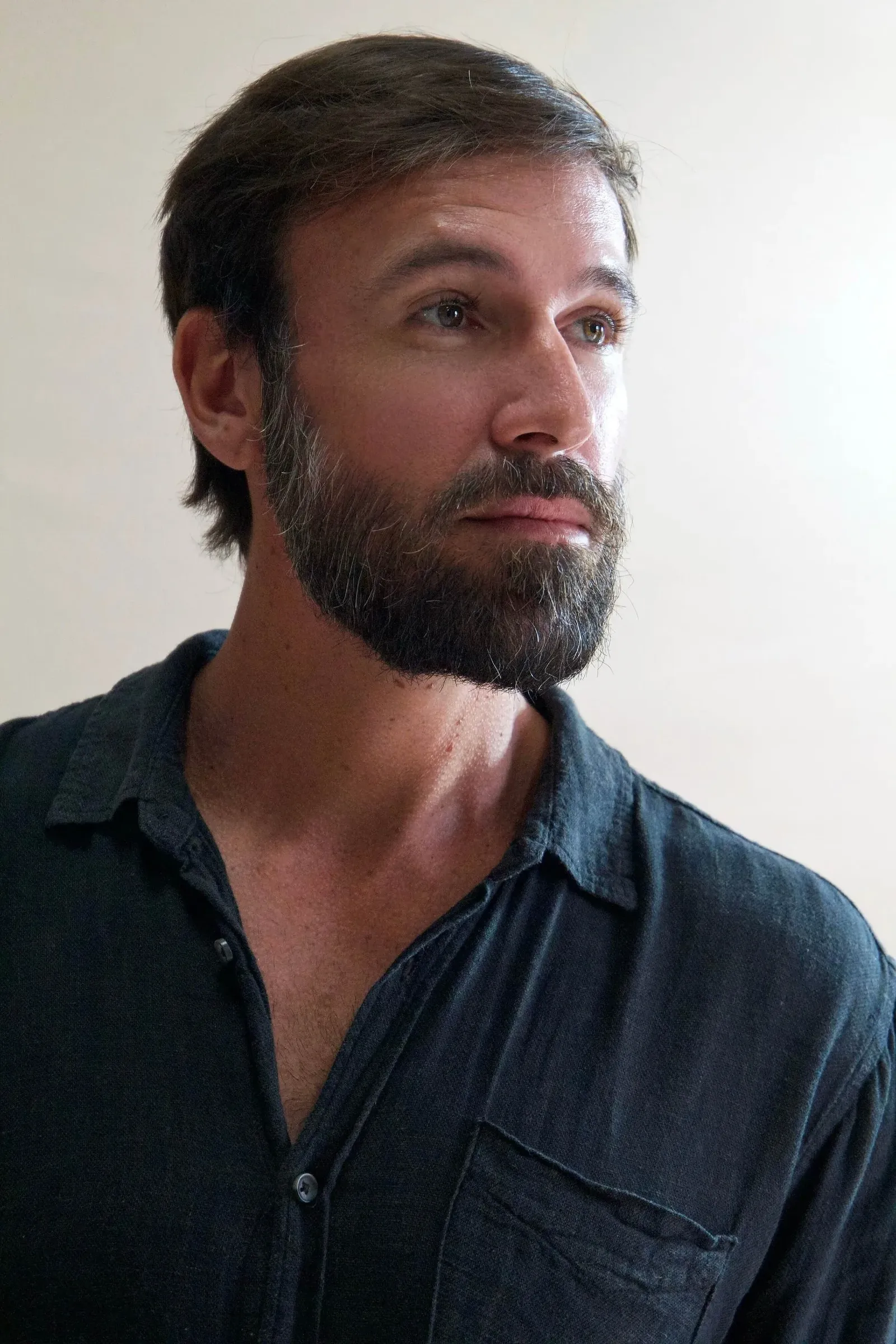 Retrato de Vini Cavalieri de camisa escura, olhando para o lado