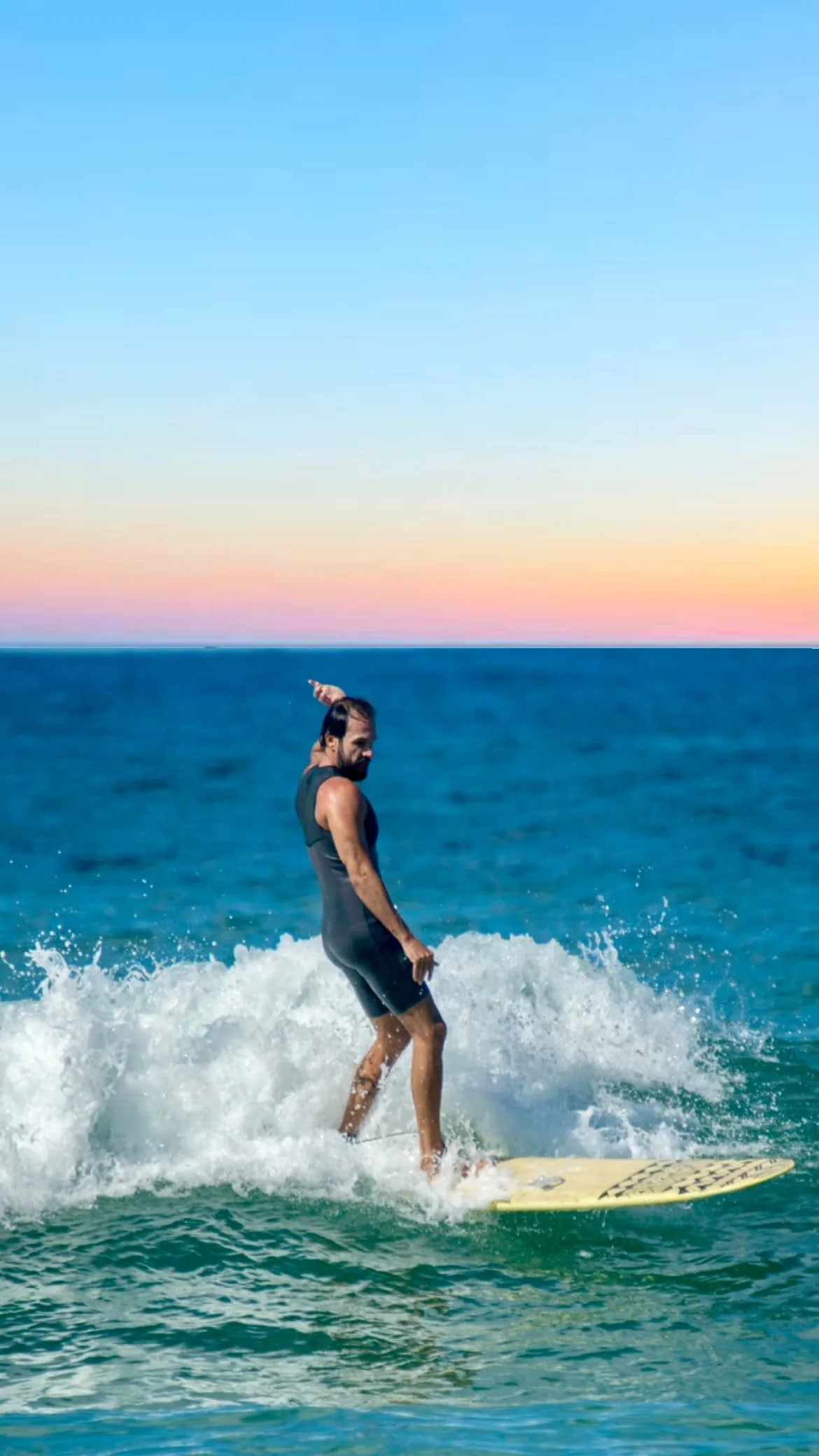 Vini Cavalieri surfando ao pôr do sol